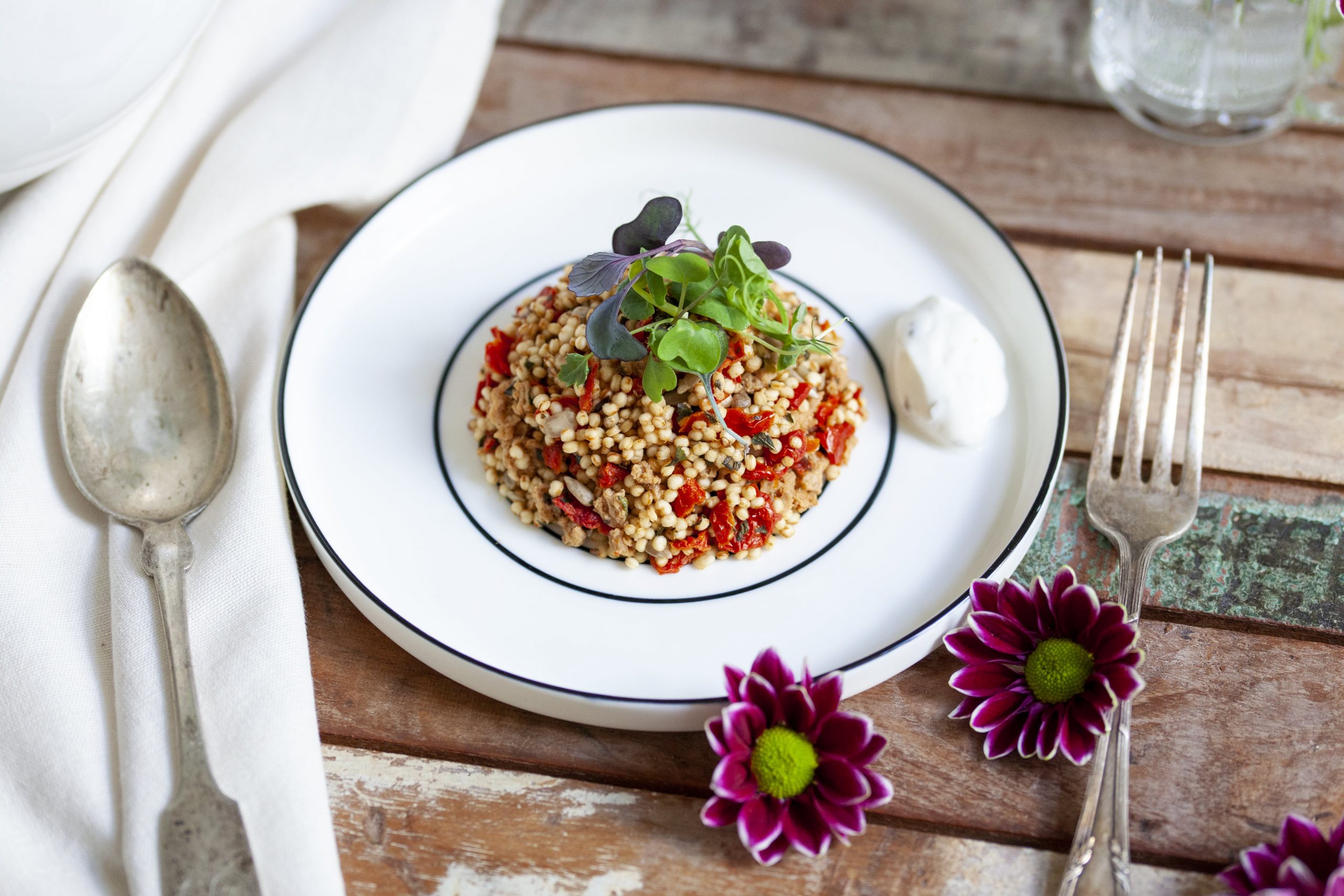Quinoa Paradeiser Mix garniert auf gedecktem Tisch